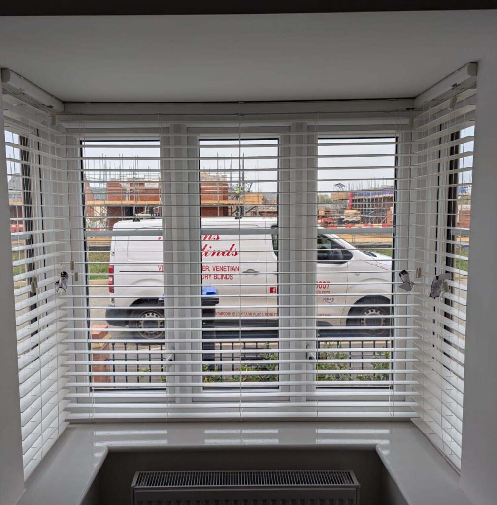 Local Blinds Transformations - Recent Projects in Northamptonshire - this image shows wooden venetian blinds installed in a bay window in Northamptonshire with the Gillian's Blinds van in the background