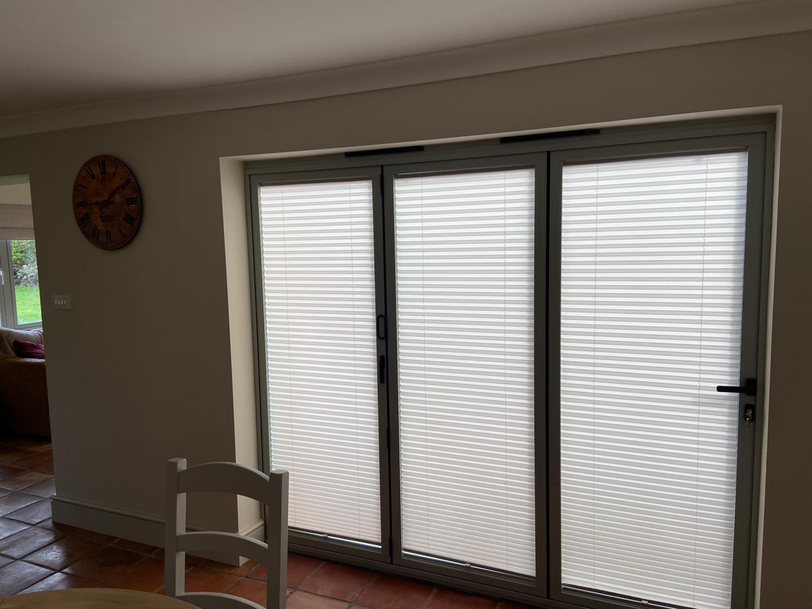 Pleated blinds fitted within bifold doors in Bugbrooke Northamptonshire home