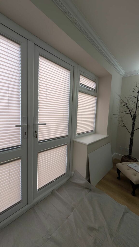 Pleated blinds fitted within door and side window frames in Roade Northamptonshire providing a neat finish with improved privacy and light control