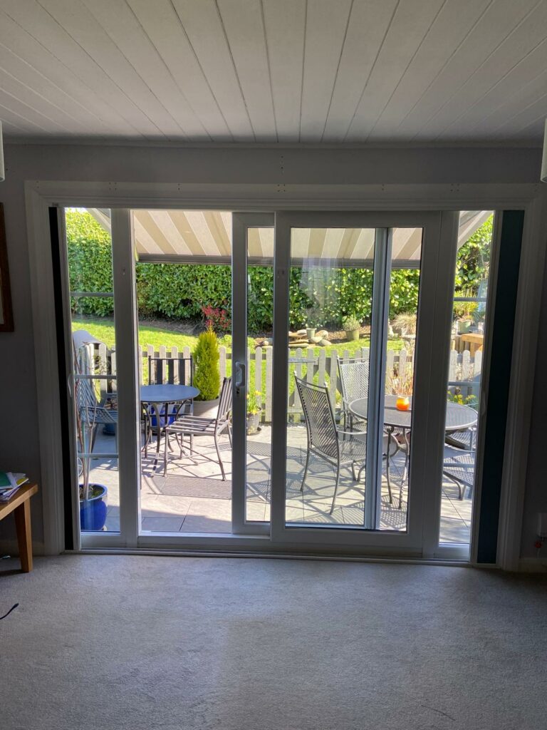 Modern Blind Screen system installed across large sliding patio doors in Northamptonshire home allowing natural light, garden views and flexible privacy control