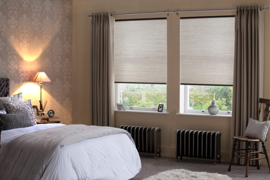 Soft neutral roller blinds in a calming modern bedroom with warm taupe tones