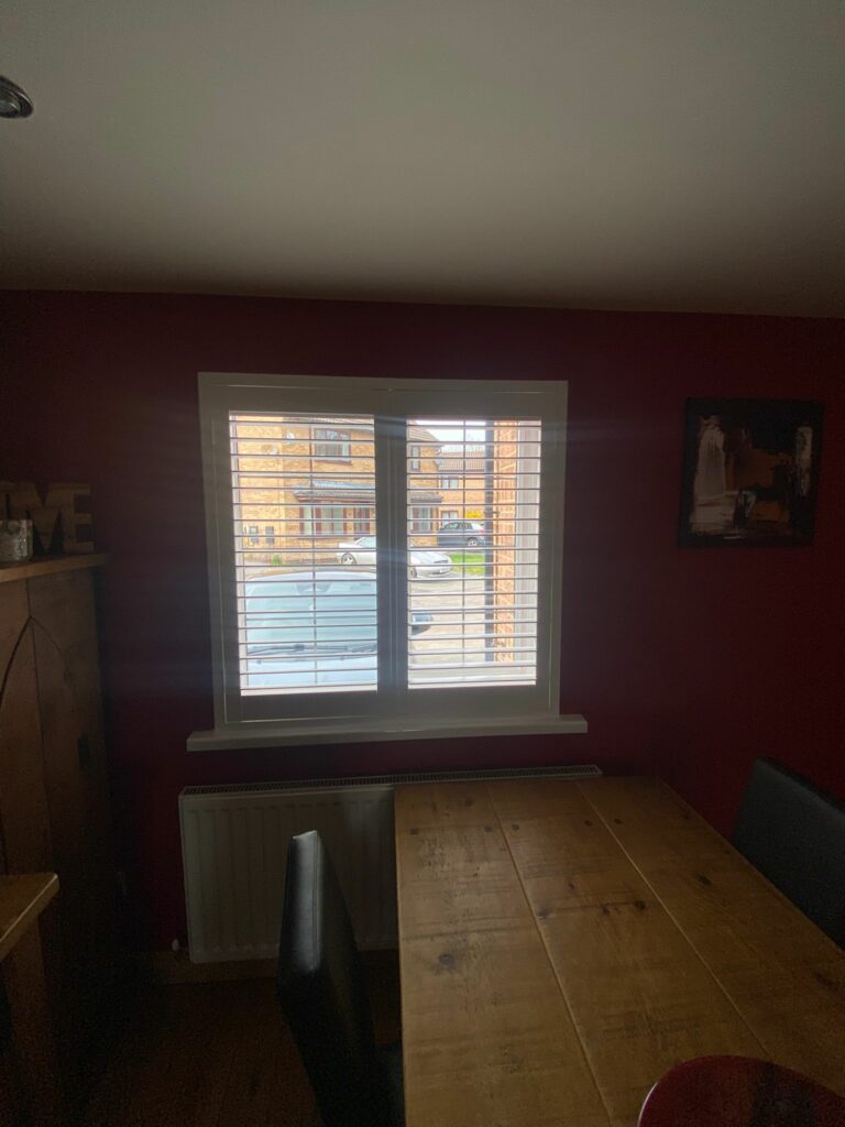Made to measure plantation shutters fitted in Daventry home offering privacy for front-facing dining room windows while maintaining daylight