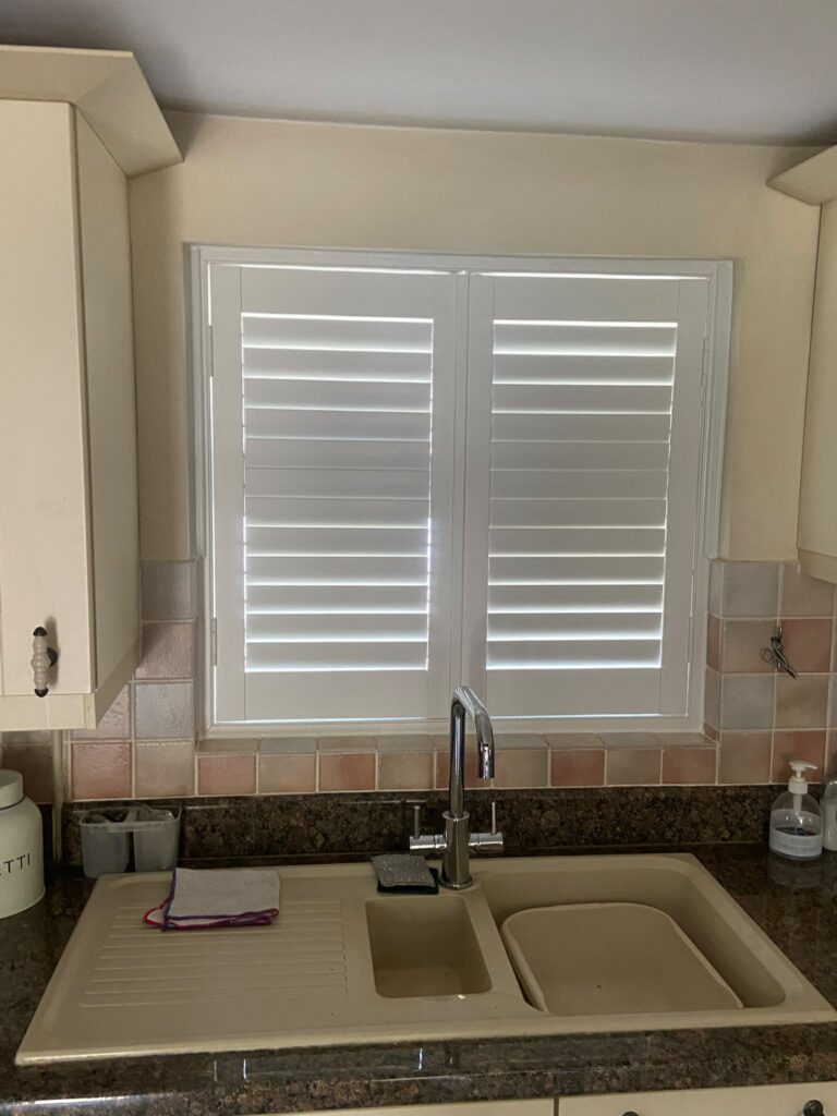 Closed UPVC shutters fitted behind a kitchen sink in Brackley