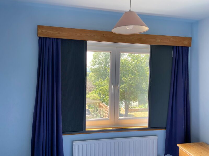 Partially drawn outside-recess Blind Screen around a tilt-and-turn window with blue curtains in Northampton