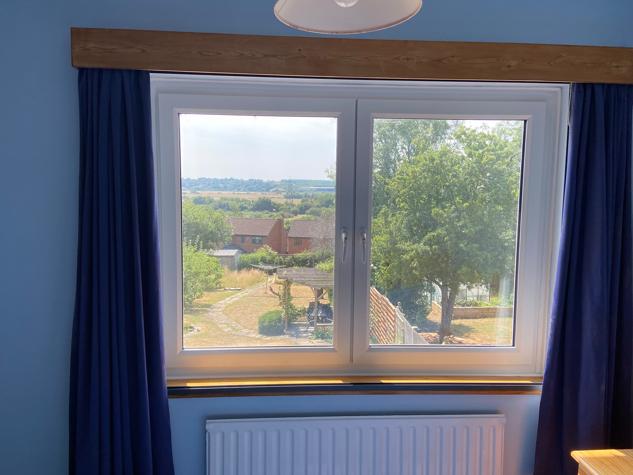 Tilt-and-turn window with the outside-recess Blind Screen fully retracted beside blue curtains