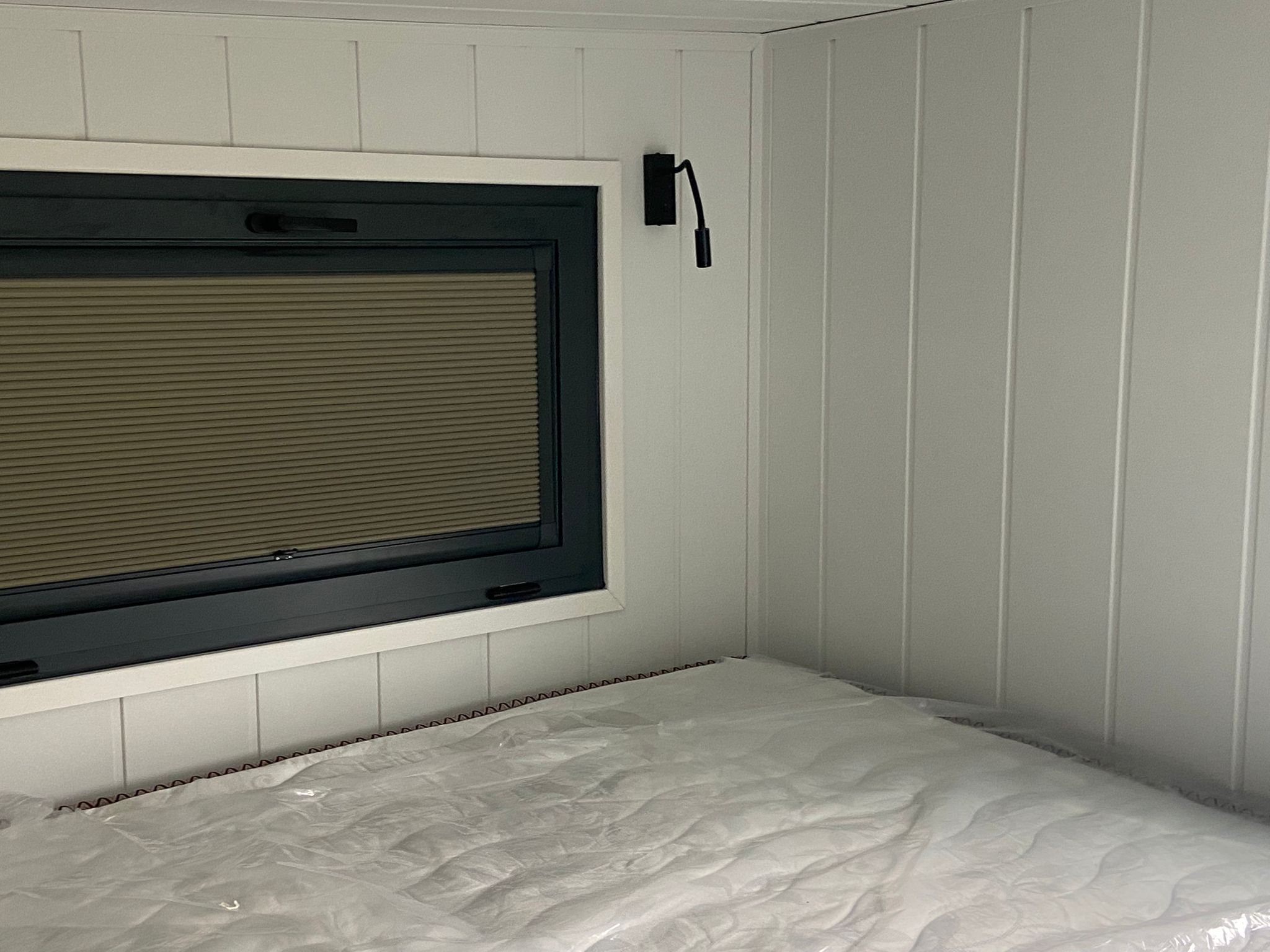 Pleated blind fitted to bedroom window in converted trailer