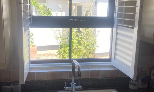 UPVC kitchen shutters fitted behind a sink in Brackley